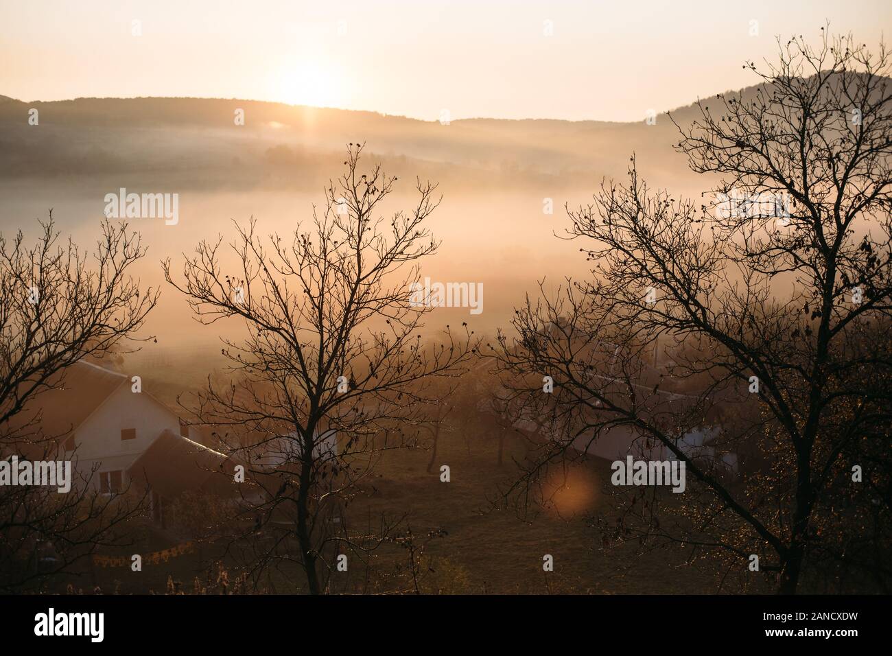 Paysage de lever de soleil brumeux dans le village de montagnes d'automne Banque D'Images