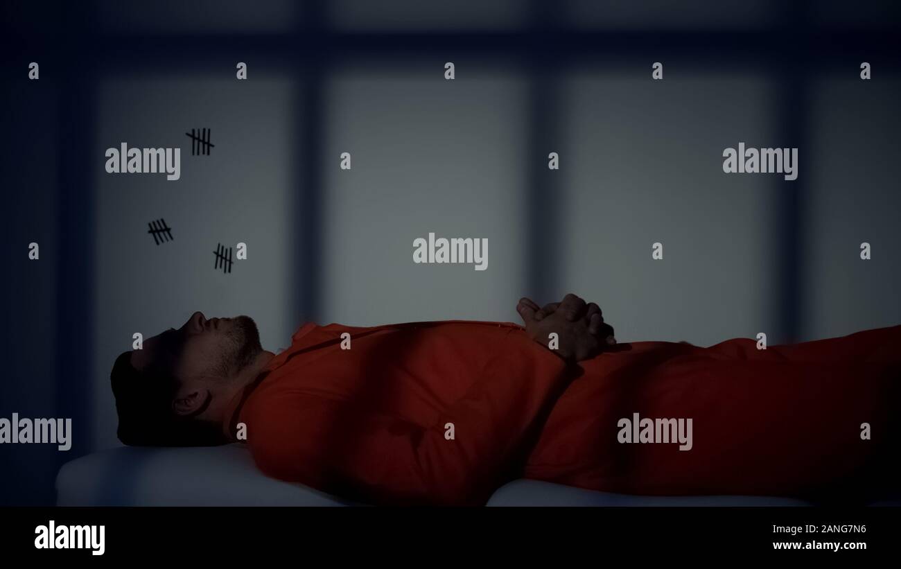 Prisonnier du Caucase de mensonge et de pensée sur plank-lit dans la cellule qui purgent une sentence Banque D'Images