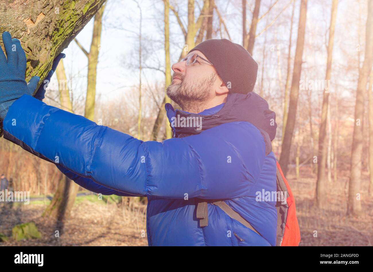 Homme d'âge moyen dans un fantôme blue Down Jacket repos dans la forêt. Banque D'Images