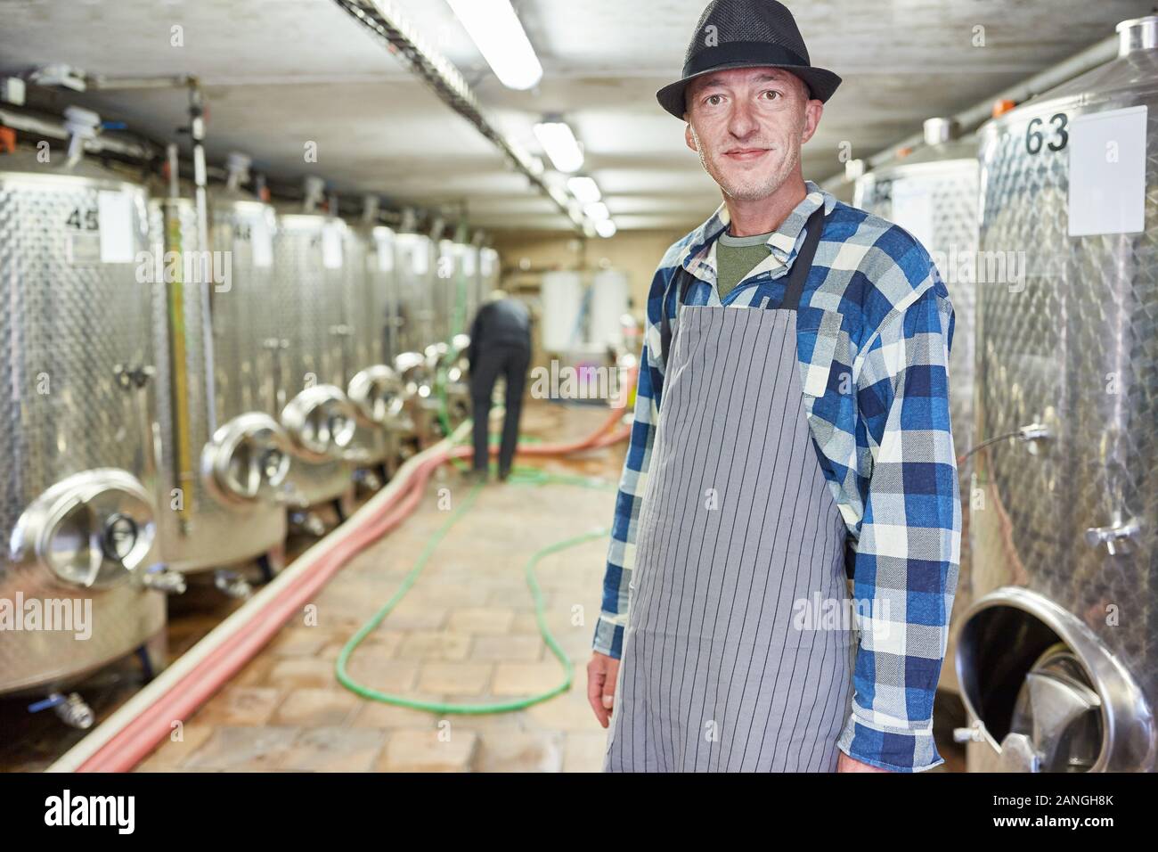 Wine master ou maître brasseur dans la cave ou de la brasserie avec cuves de fermentation Banque D'Images