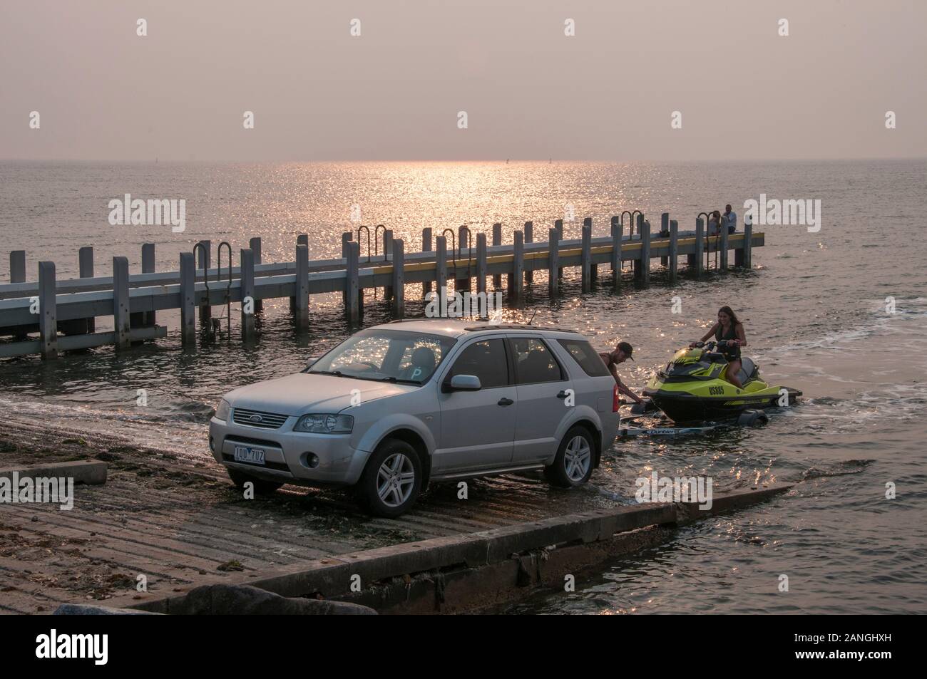 Passionné de jetski retourner à la rampe au crépuscule sur un soir brumeux, la baie de Port Phillip, Melbourne, Australie Banque D'Images