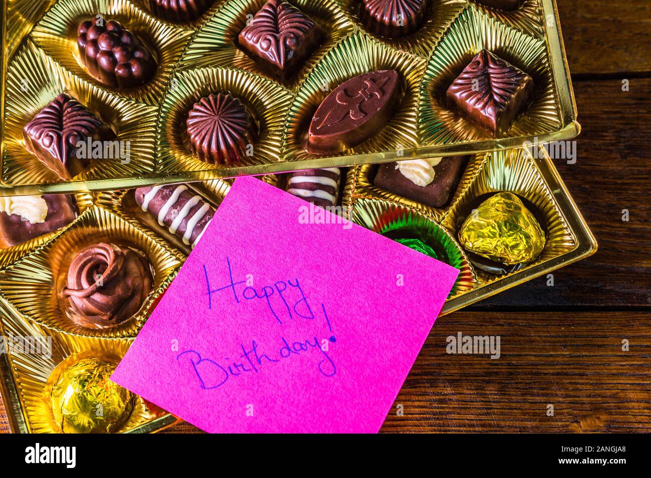 Joyeux Anniversaire Texte Sur Memo Post Rappel Pres D Une Boite En Or Avec Du Chocolat Pralines Photo Stock Alamy