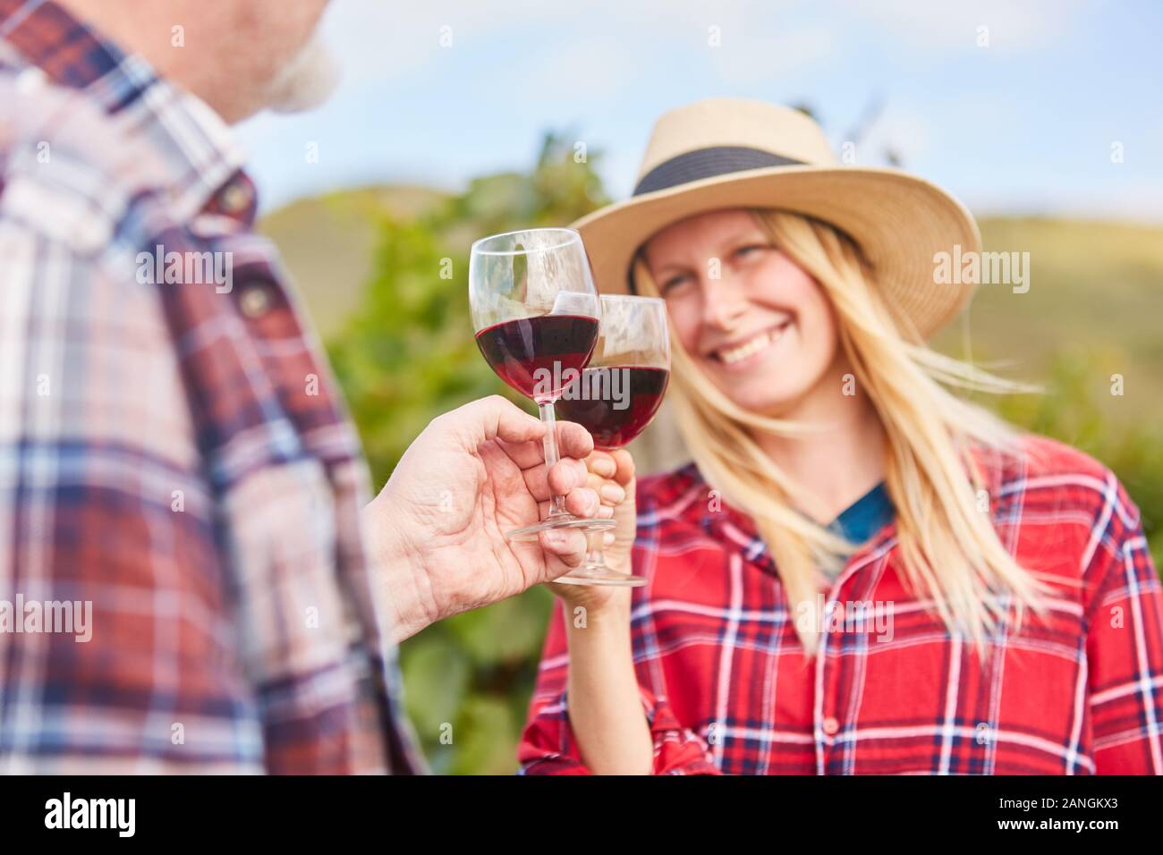 Young woman toasting avec un verre de vin rouge à une dégustation de vin Banque D'Images