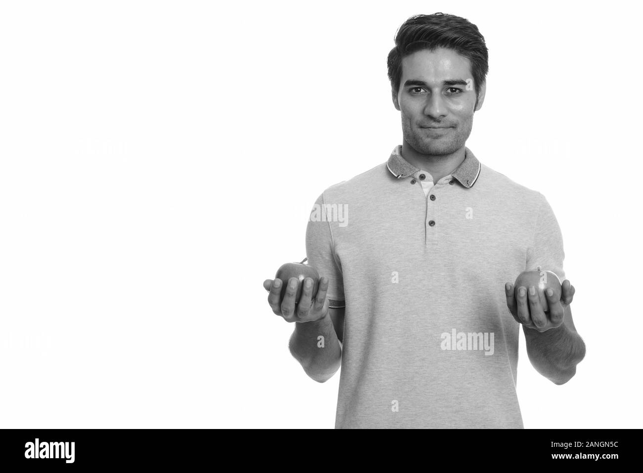 Les jeunes professionnels Persian man holding red et green apple Banque D'Images