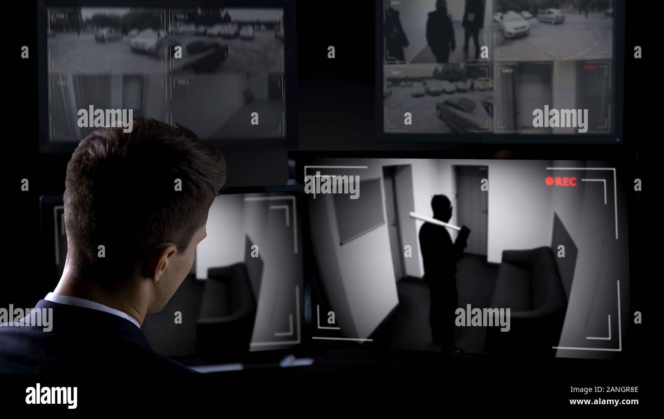 Garde de sécurité homme regardant dans le bâtiment de frein bandit, CCTV footage, scène du crime Banque D'Images