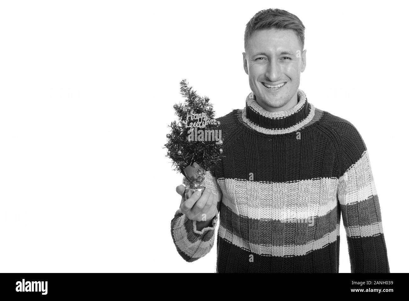 Happy handsome Young man holding Happy New Year tree Banque D'Images