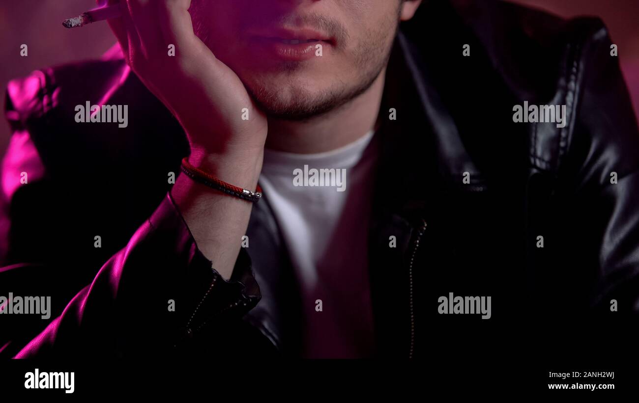 Jeune homme à la cigarette à partie, l'impact de la nicotine sur la santé de la fumée toxique Banque D'Images