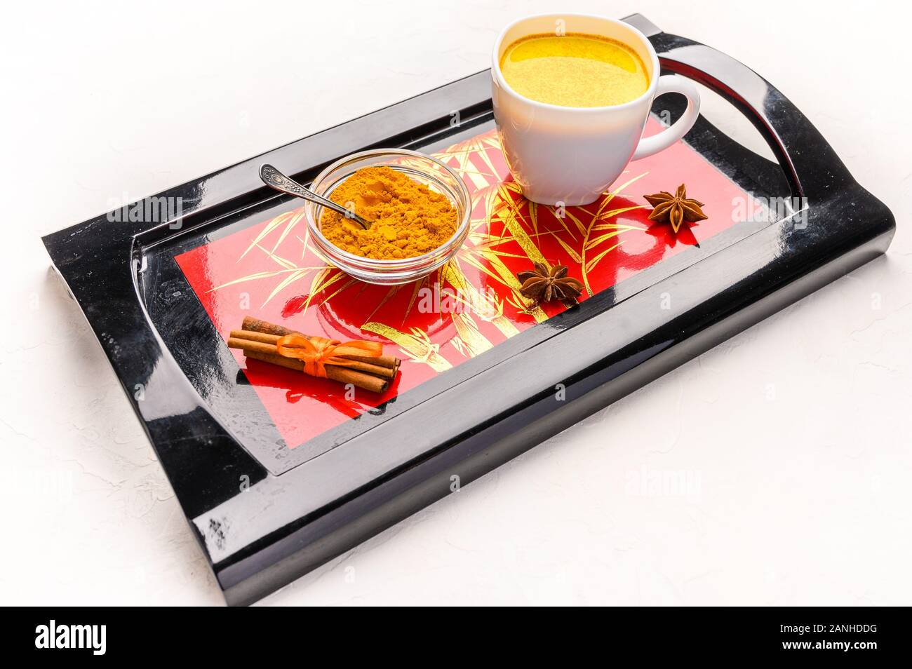 Masala chai thé indien traditionnel avec des épices, de la cannelle, d'anis et de cardamome dans une tasse blanche sur un plateau noir Banque D'Images