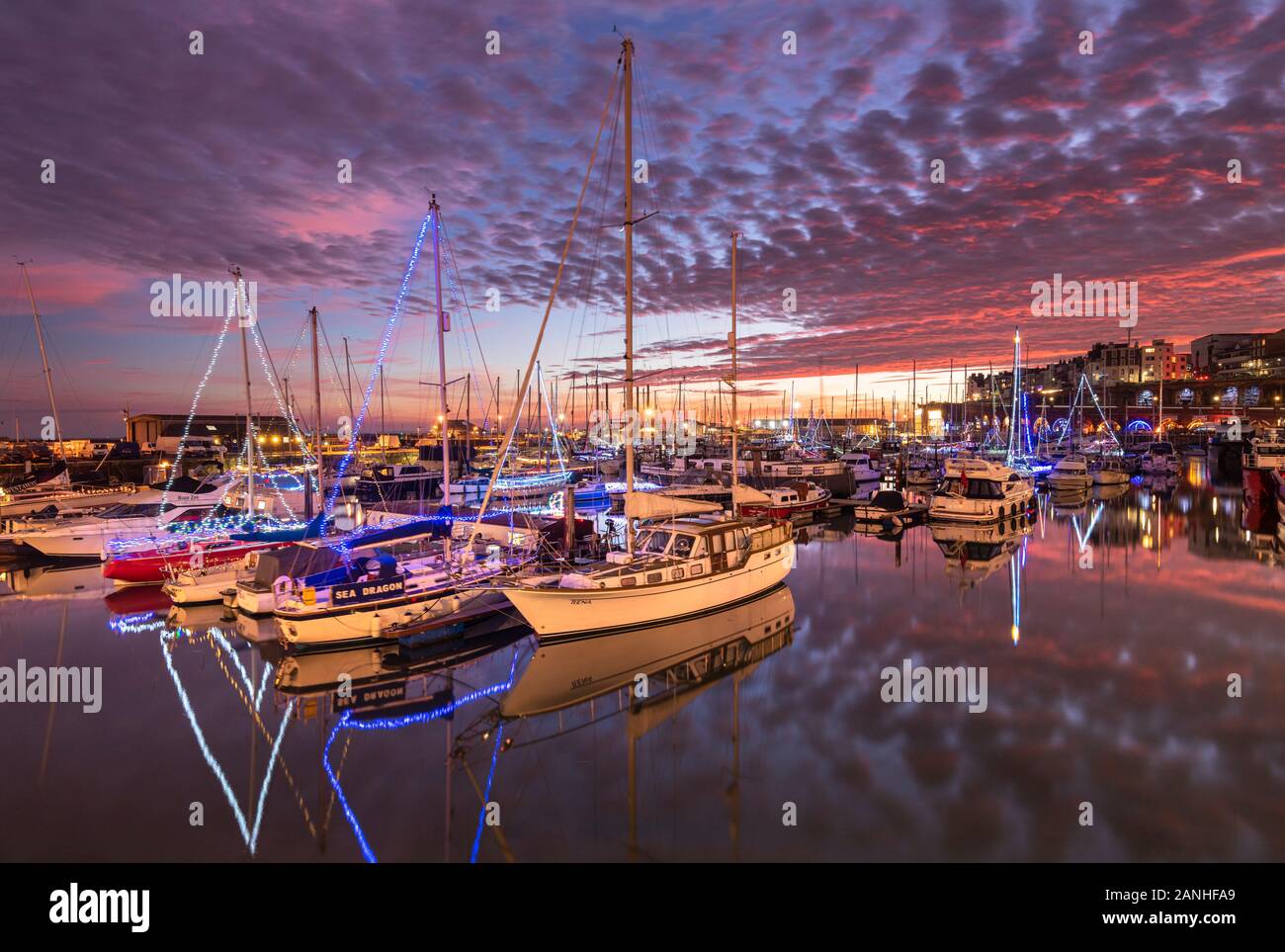 Les bateaux et yachts illuminés par des lumières de noël à la marina de Ramsgate Royal Harbour dans le Kent. Banque D'Images