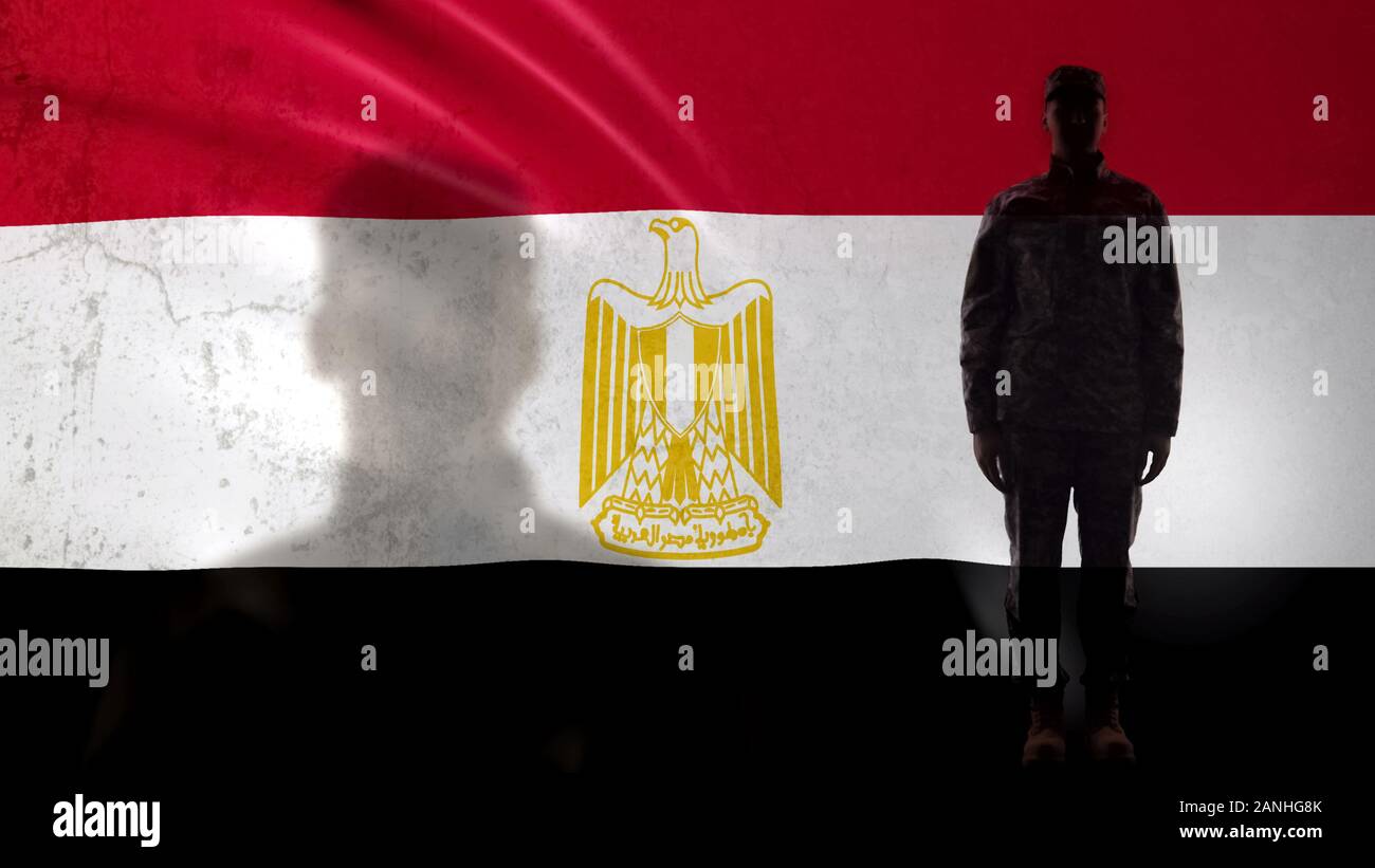 Soldat égyptien silhouette debout contre le drapeau national, fier sergent dans l'armée Banque D'Images