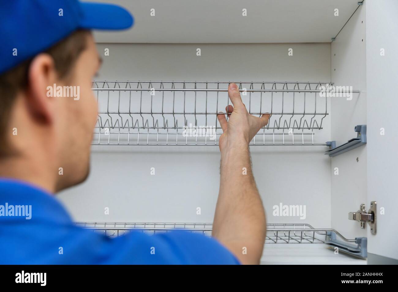 Travailleur des services de l'installation de meubles meuble de cuisine panier à vaisselle Banque D'Images