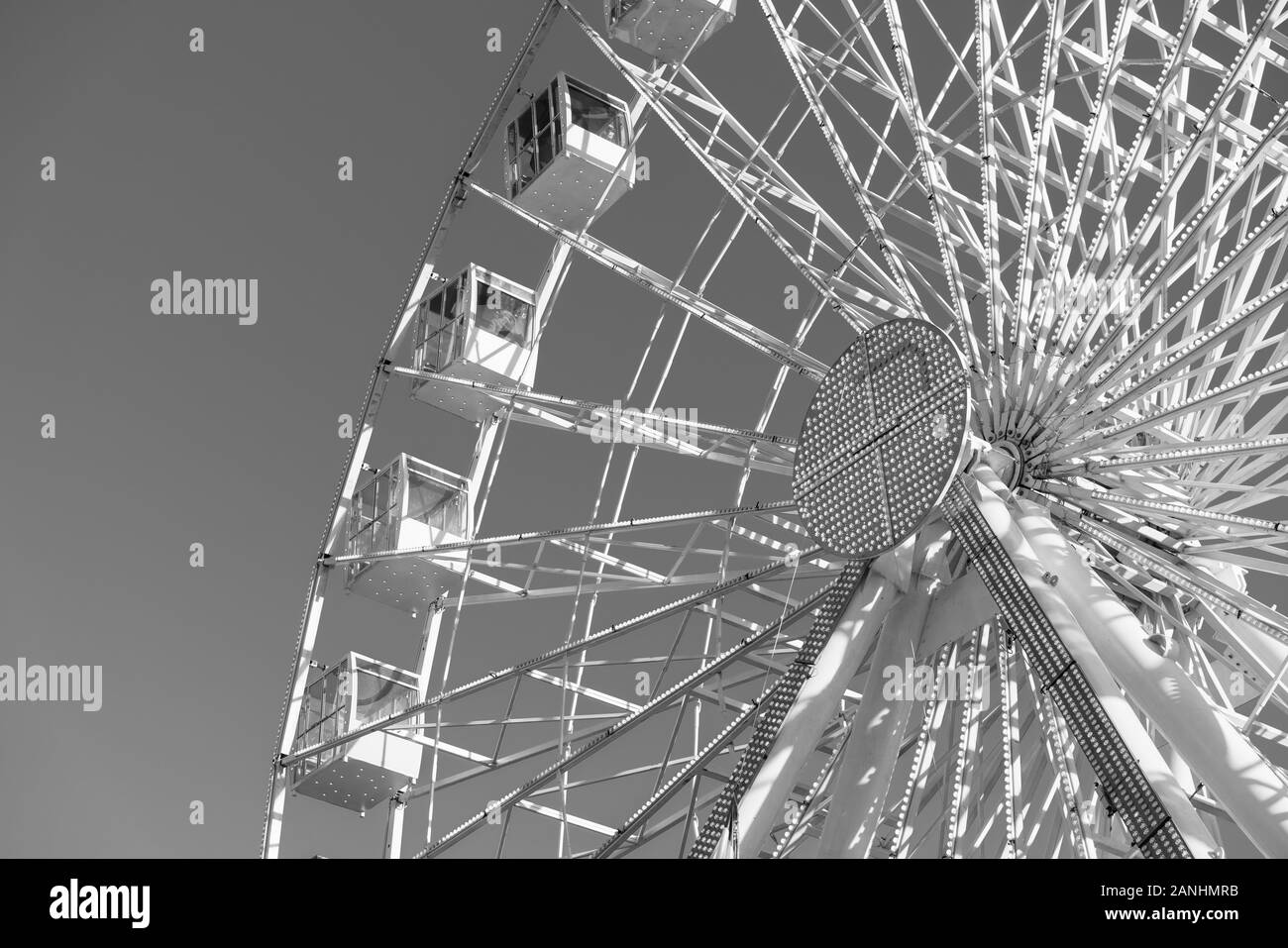 Grande roue tourne sur fond gris. Les gens sont à cheval et profiter d'une vue panoramique weel vue sur la ville. Low angle view, copiez l'espace et la macrophotographie Banque D'Images