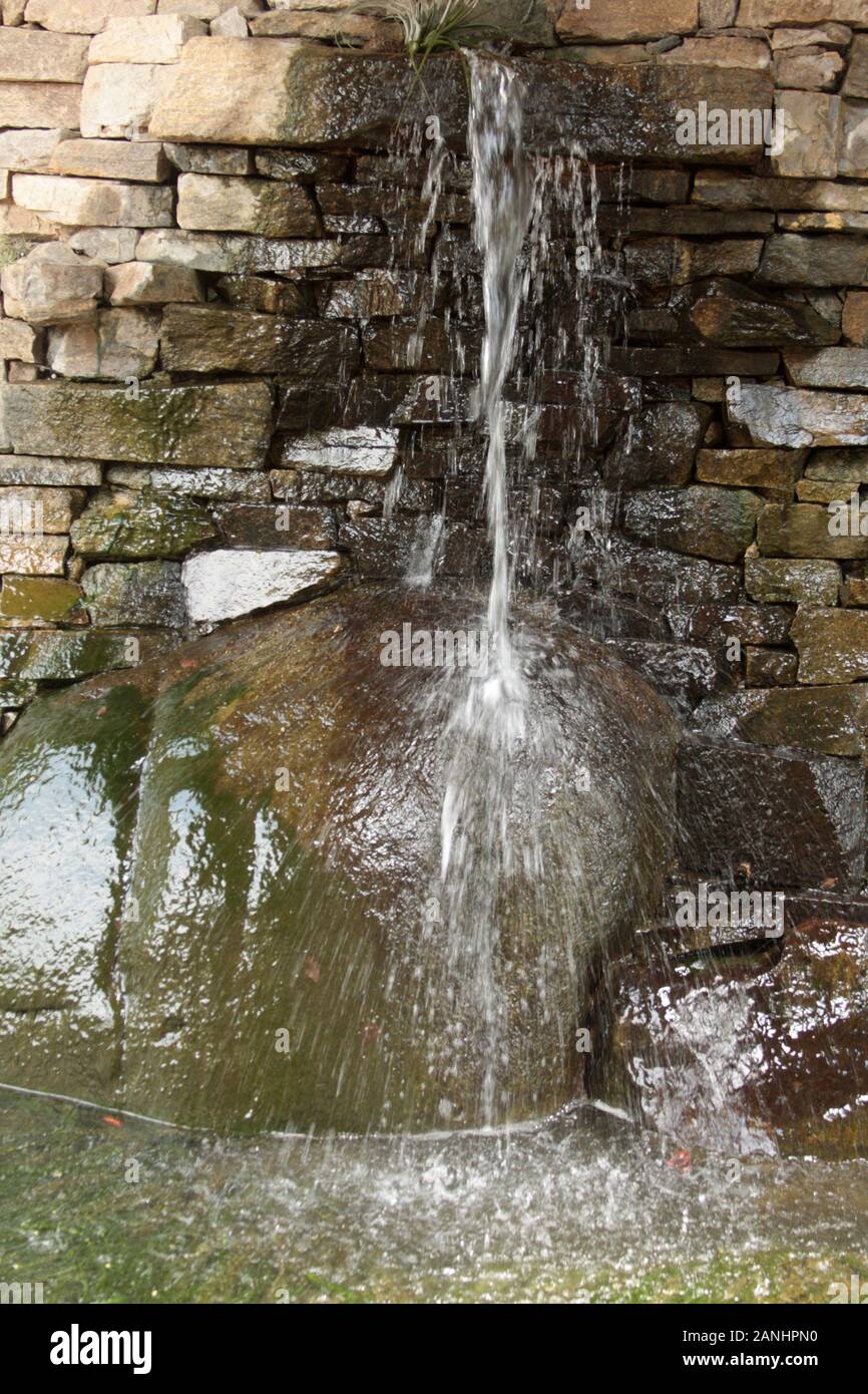 Fontaine d'eau ornementale avec mur arrière de roche Banque D'Images