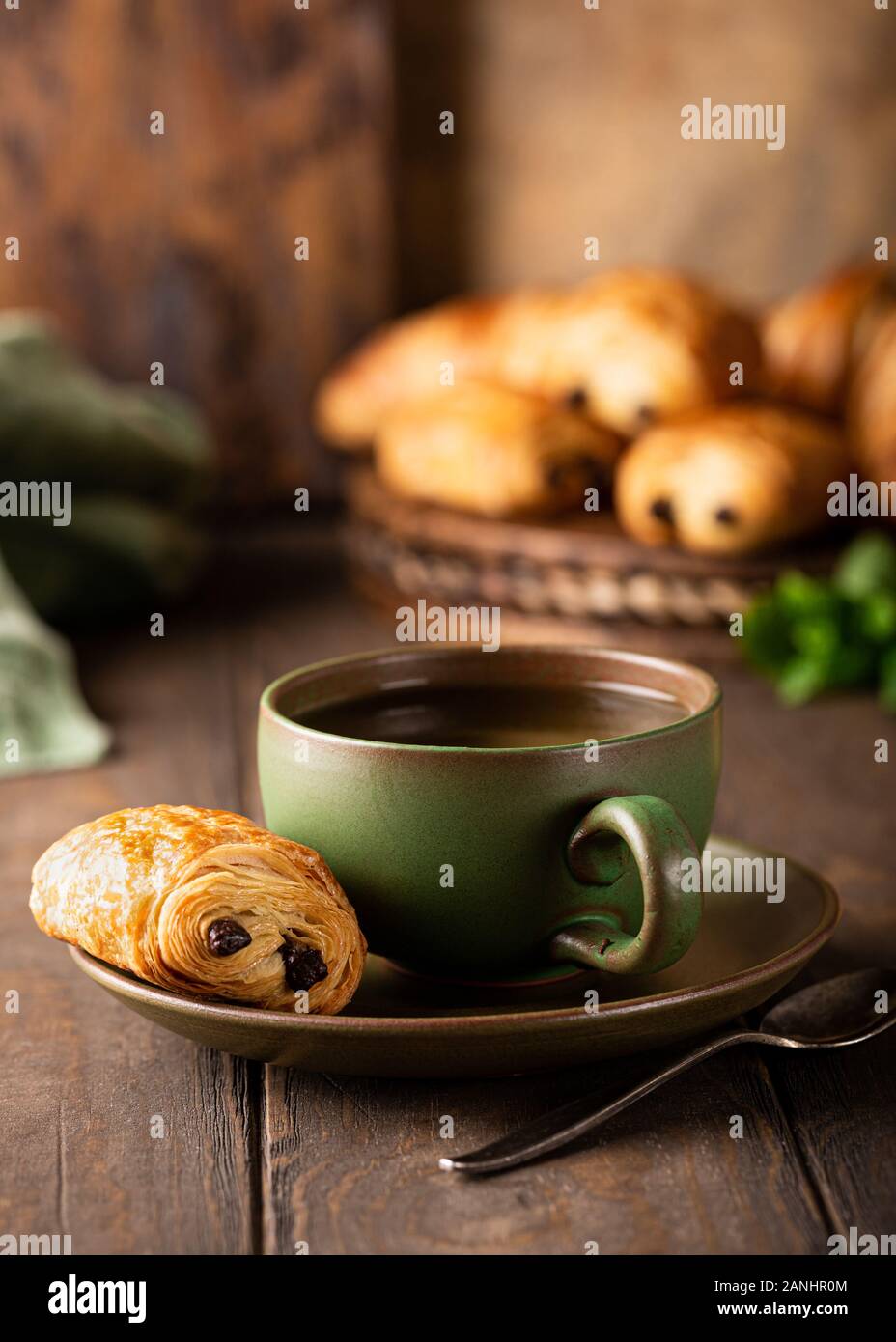 Tasse de thé vert avec un mini pain au chocolat Banque D'Images