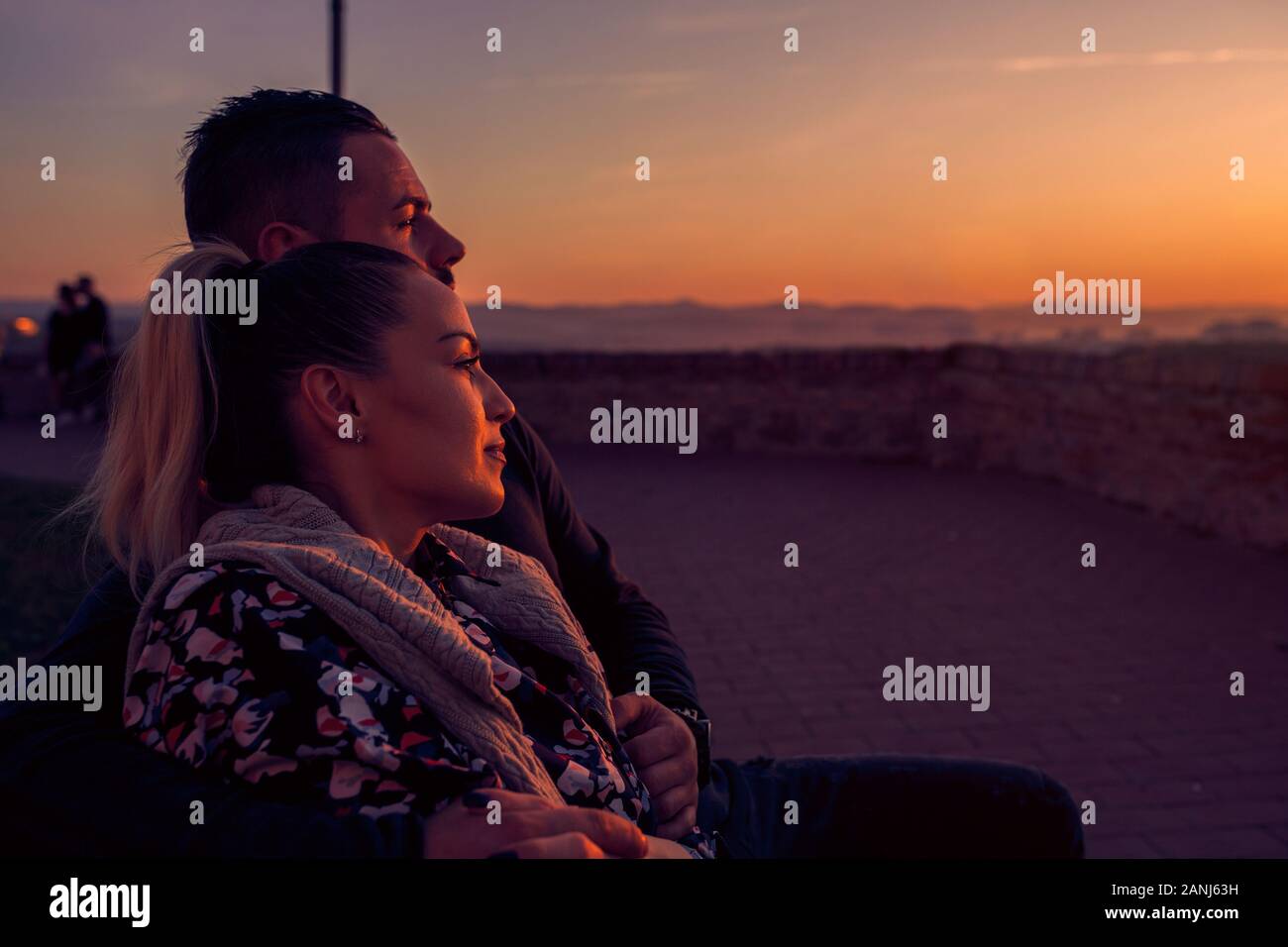 Couple aimant à regarder le coucher du soleil du soir Banque D'Images