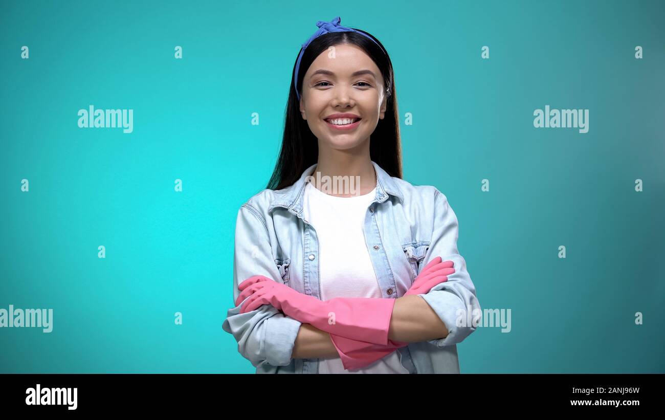 Confiant dans les gants femme debout avec les mains croisées et smiling at camera Banque D'Images