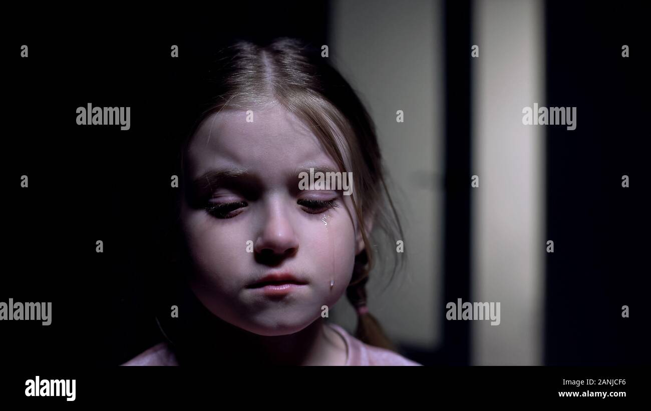 Girl crying in dark room, victime de l'intimidation, pour les enfants, protection des droits de l'enfance Banque D'Images