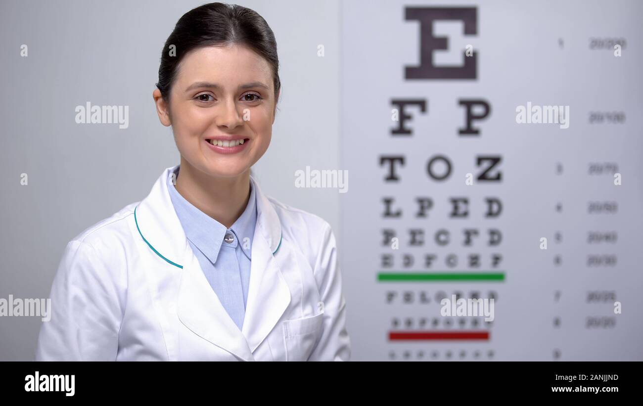 Dame ophtalmologiste satisfait de la vue tableau des résultats de l'épreuve, une bonne vision Banque D'Images