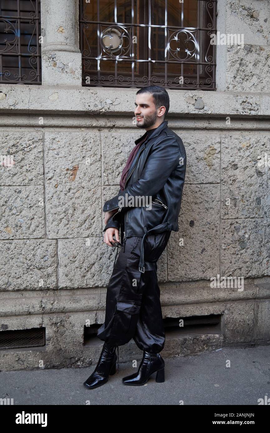 MILAN, ITALIE - 13 janvier 2019 : l'homme avec veste en cuir noire et hautes chaussures de talon avant de Reshake fashion show, Milan Fashion Week street style ? Banque D'Images