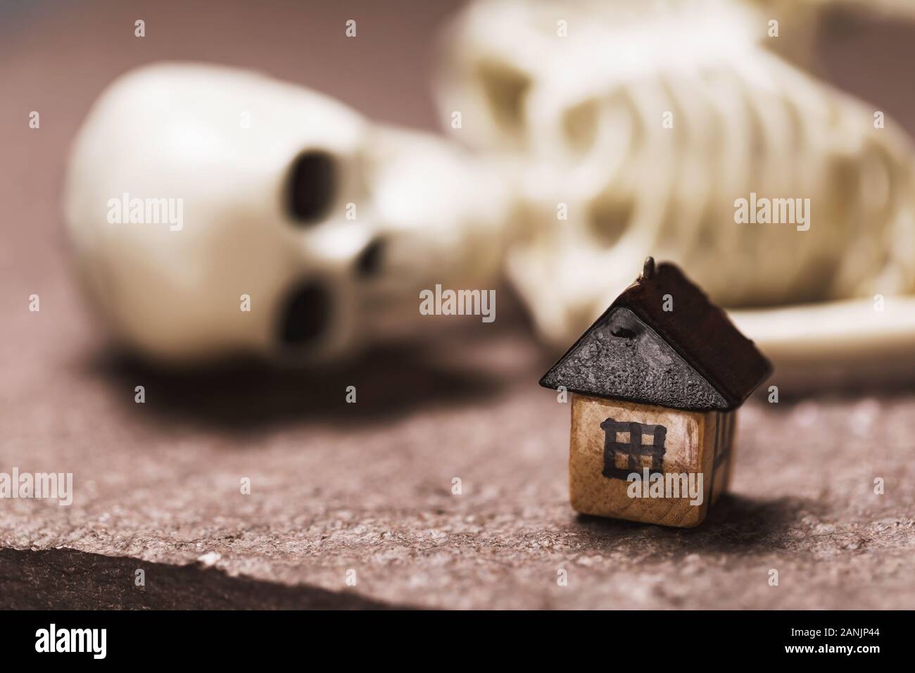 Petite maison en bois et squelette humain close-up. Le concept de la partie non expirée de rêve dans l'achat d'une maison Banque D'Images