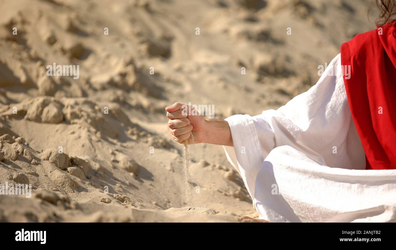 Homme de robe verser le sable, symbole de la vie qui passe, le temps presse Banque D'Images