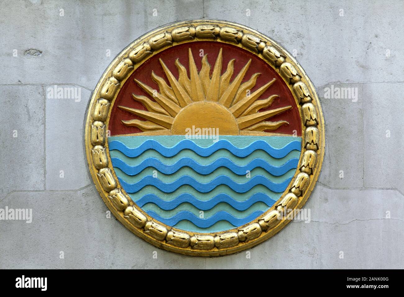 L'un des nombreux panneaux ronds sur le côté de l'Inde Maison, Aldwych, London. Celui-ci dispose d'un lever de soleil (ou paramètre ?) au-dessus de l'eau. Banque D'Images