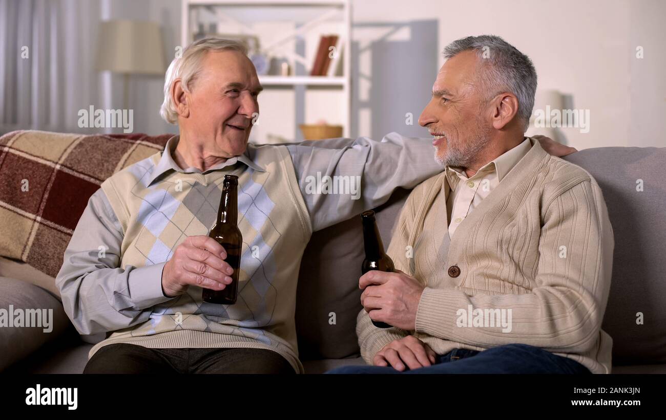 Old Friends holding beer bottles, temps libre à la maison, de s'amuser ensemble Banque D'Images