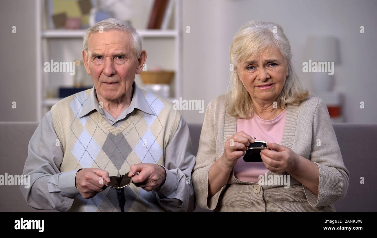 Couple âgé bouleversé les sacs à vide montrant à la caméra, la réforme sociale, retraite Banque D'Images
