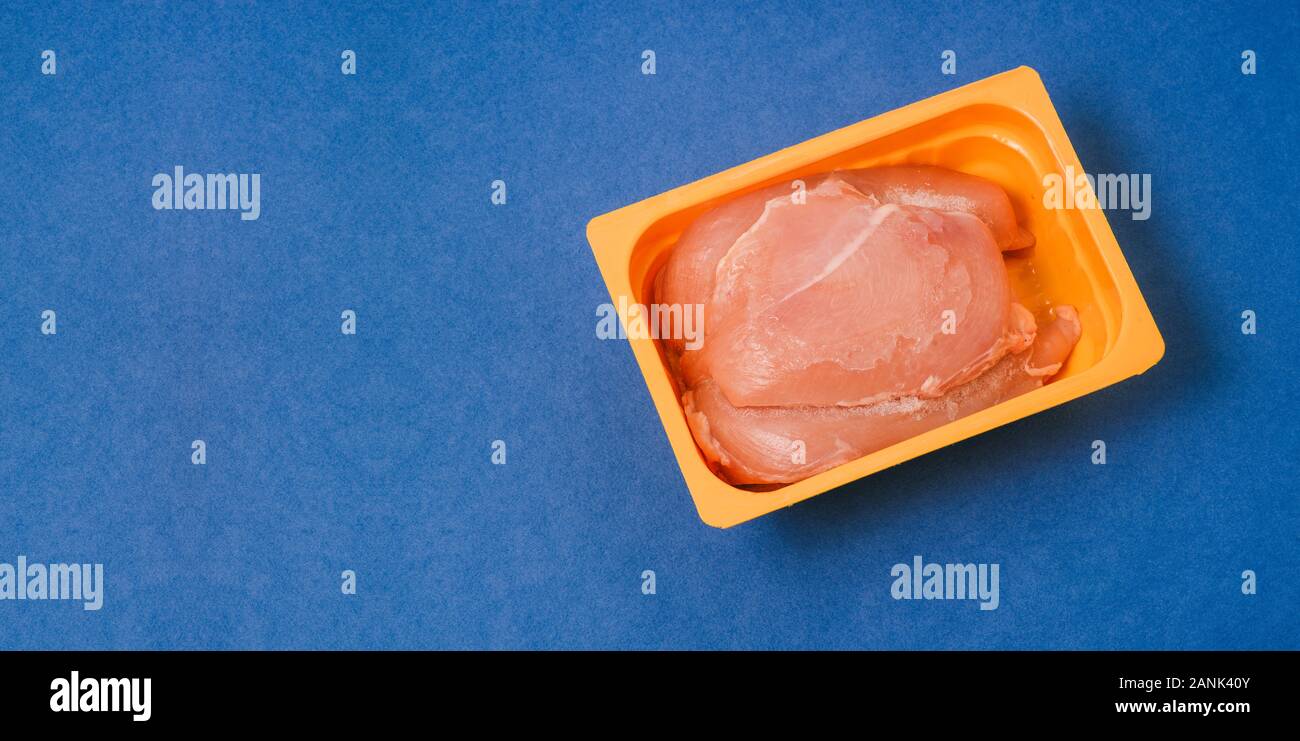 Le poulet congelé dans des contenants en plastique sur un fond bleu. Frais  sain et l'alimentation de l'alimentation. Cuisson de la volaille pour le  dîner. Copier l'espace, vue d'en haut Photo Stock -