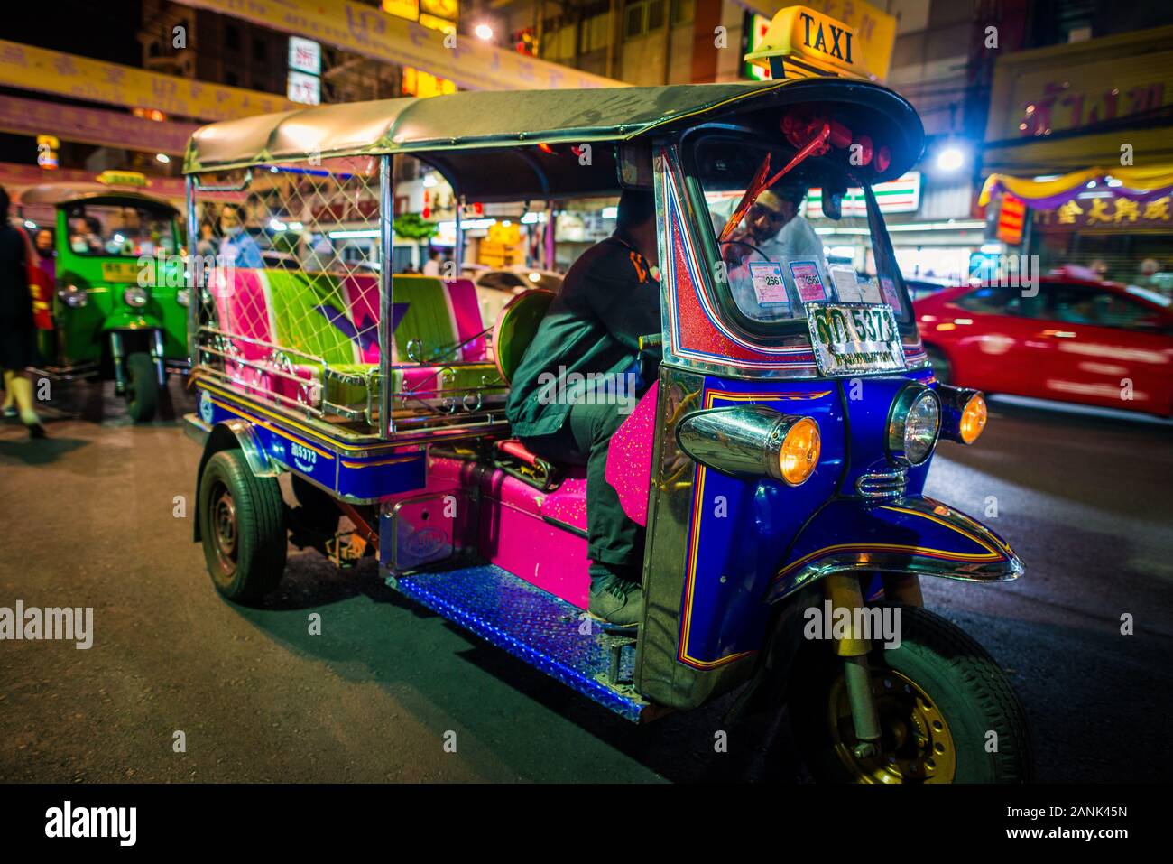 Bangkok/Thaïlande-05December2019 : célébration nocturne de l'anniversaire du roi sur la route de Yaowarat avec des bannières accrochées sur la rue et le tuktuk bleu Banque D'Images