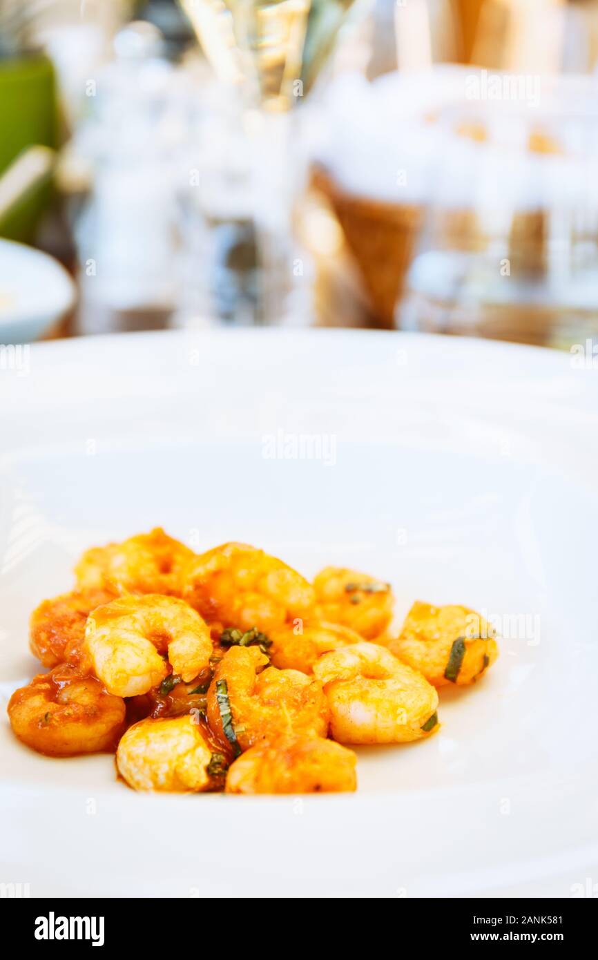 Tomate crevettes dans sause à la table. Restaurant italien à l'extérieur Terrasse. Concept de l'été repas authentique. La verticale Banque D'Images