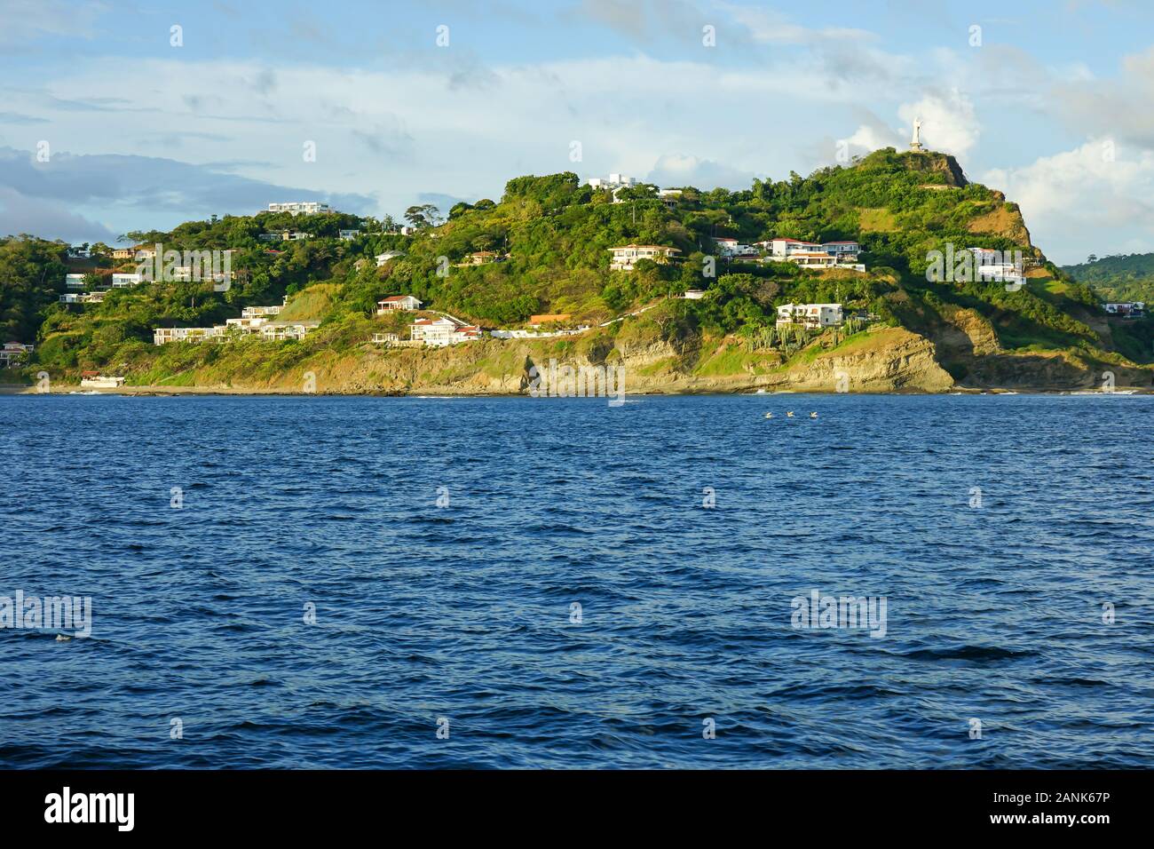 Port et Marina de San Juan Del Sur, Nicaragua, avec des bateaux et la statue du Christ de la miséricorde, avec resorts et locations de propriétés et logements. Banque D'Images