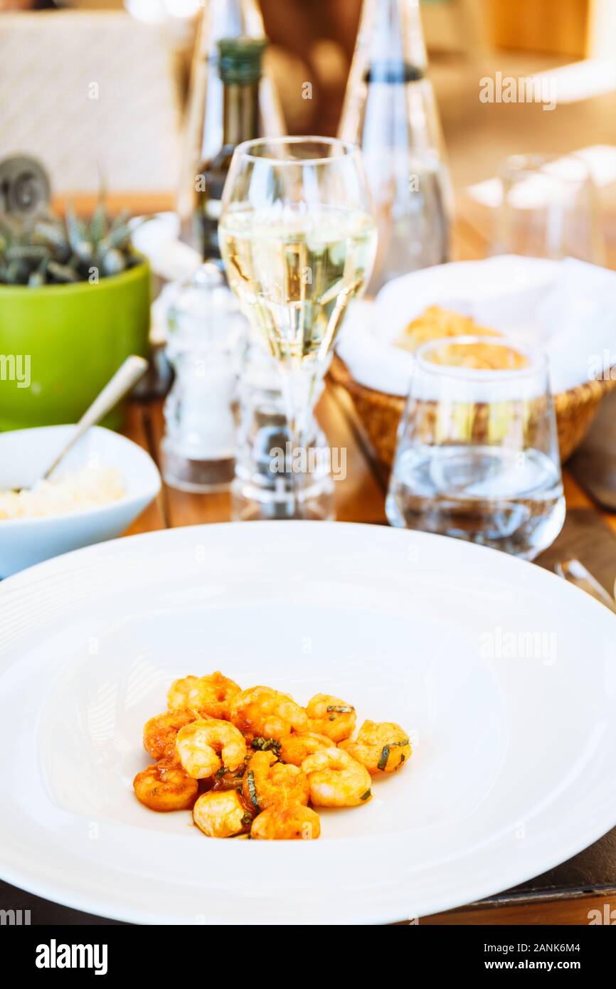 Tomate crevettes dans sause à la table. Restaurant italien à l'extérieur Terrasse. Concept de l'été repas authentique. La verticale Banque D'Images