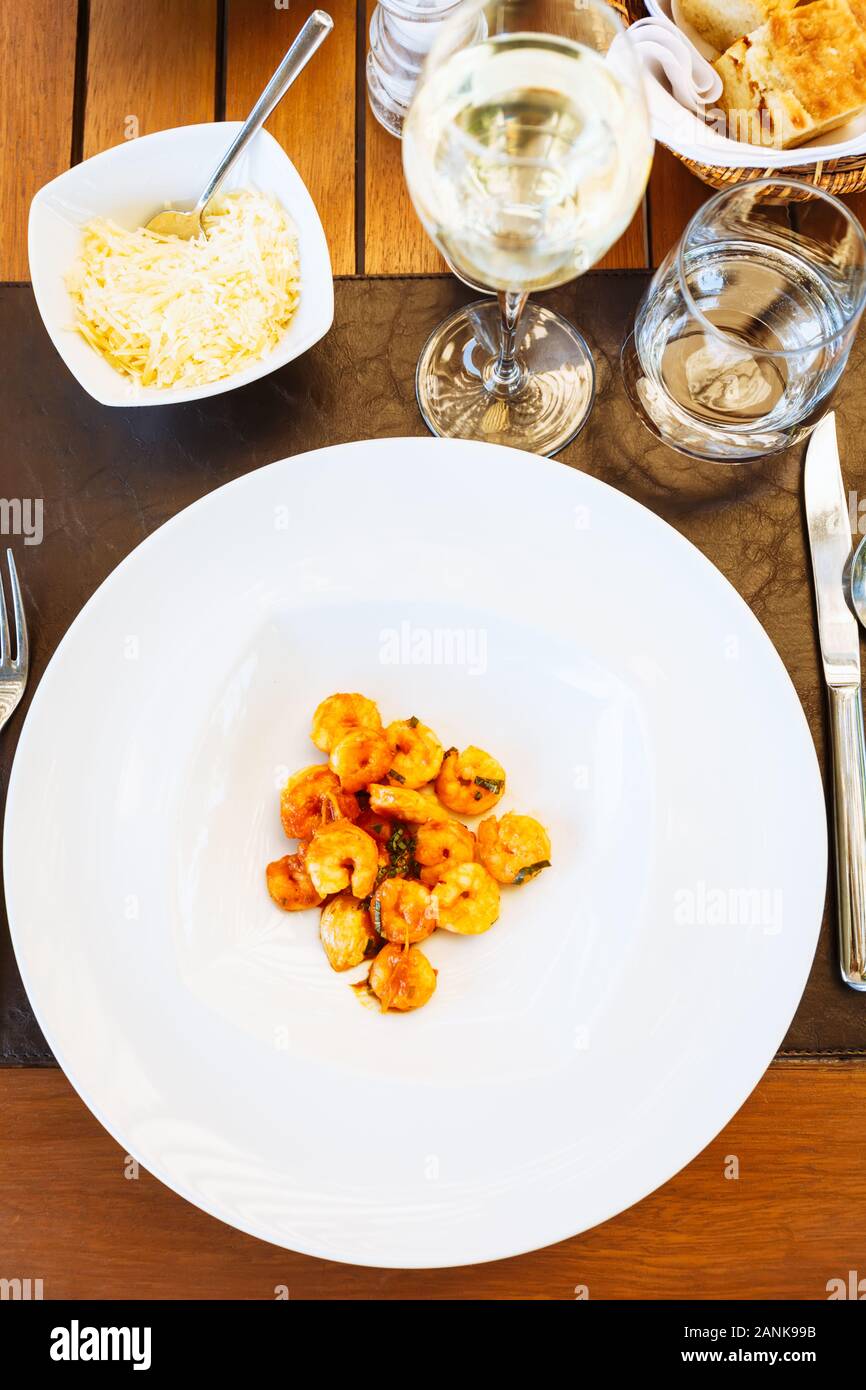 Tomate crevettes dans sause à la table. Restaurant italien à l'extérieur Terrasse. Concept de l'été repas authentique. La verticale Banque D'Images