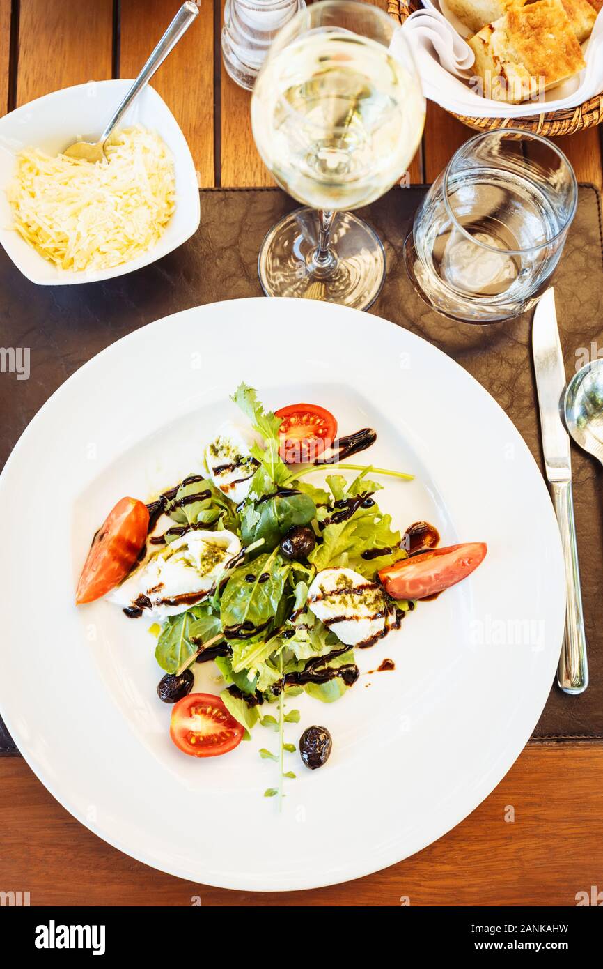 Salade Caprese à la table. Restaurant italien à l'extérieur Terrasse. Concept de l'été repas authentique. La verticale Banque D'Images
