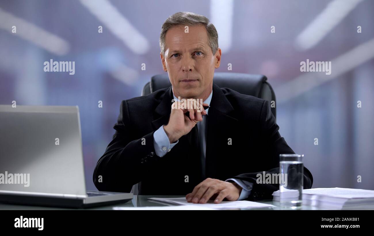 Employeur assis à table et à la caméra au bureau de l'occupation, concept Banque D'Images