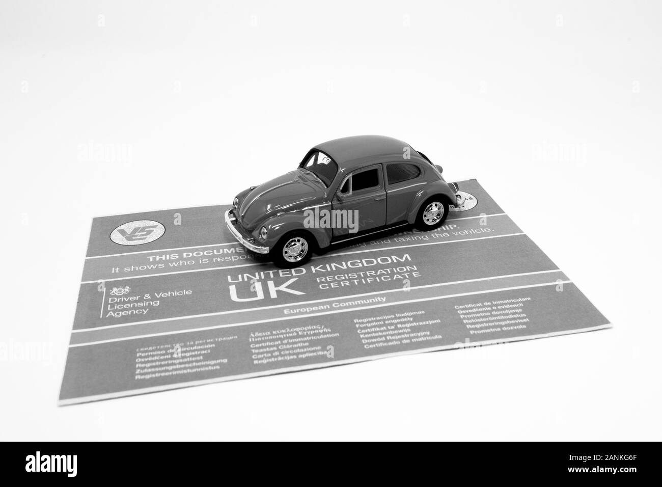 Jouet rouge Volkswagen Beetle avec un document V5C. Banque D'Images