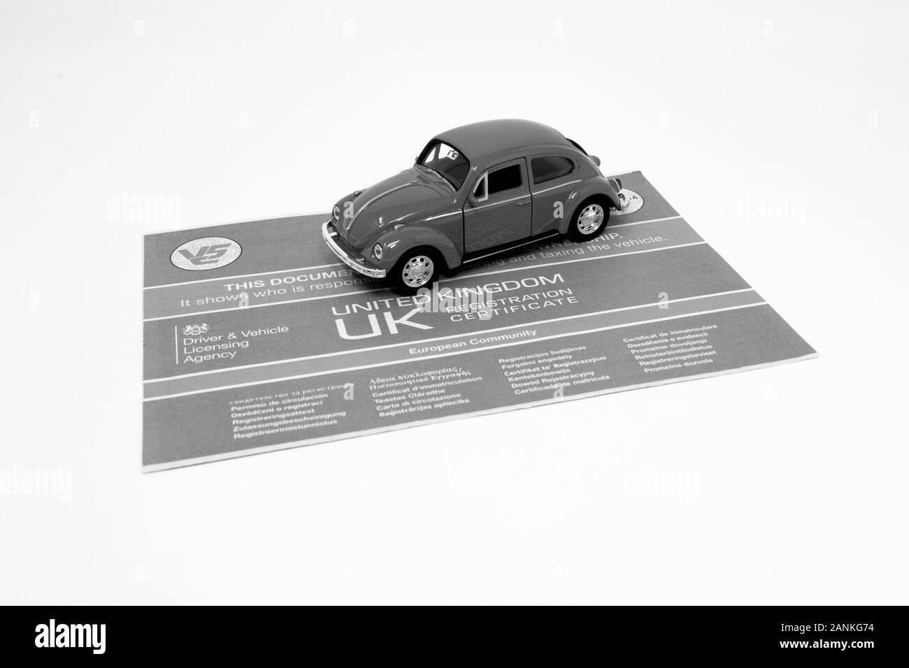 Jouet rouge Volkswagen Beetle avec un document V5C. Banque D'Images