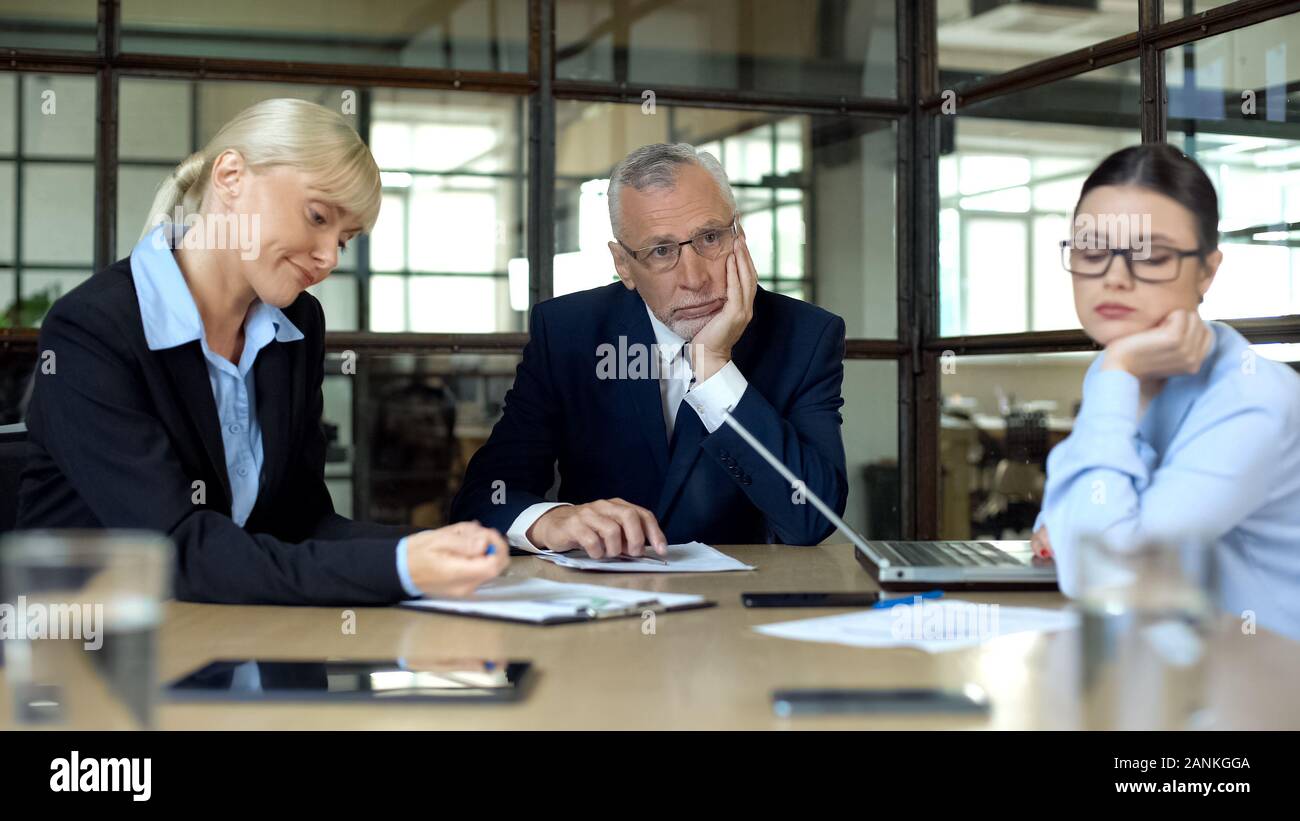 Les employés de l'entreprise s'ennuie assis à table, manque d'idées, souffrant d'épuisement professionnel Banque D'Images