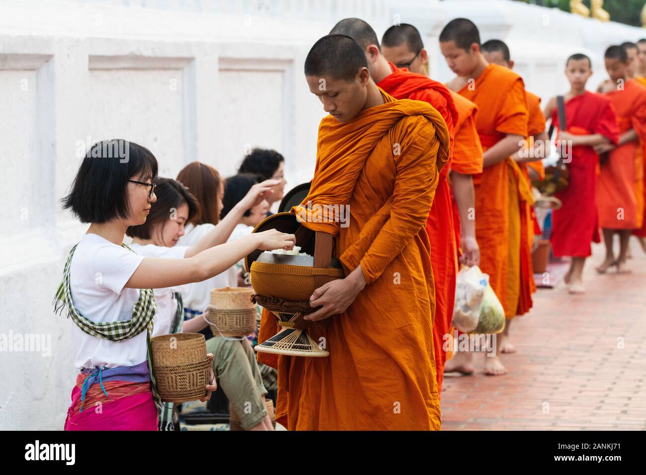 Luang Prabang, Laos - Mai 2019 : femme laotienne en faisant des offrandes aux moines bouddhistes pendant la cérémonie traditionnelle aumône matin Banque D'Images