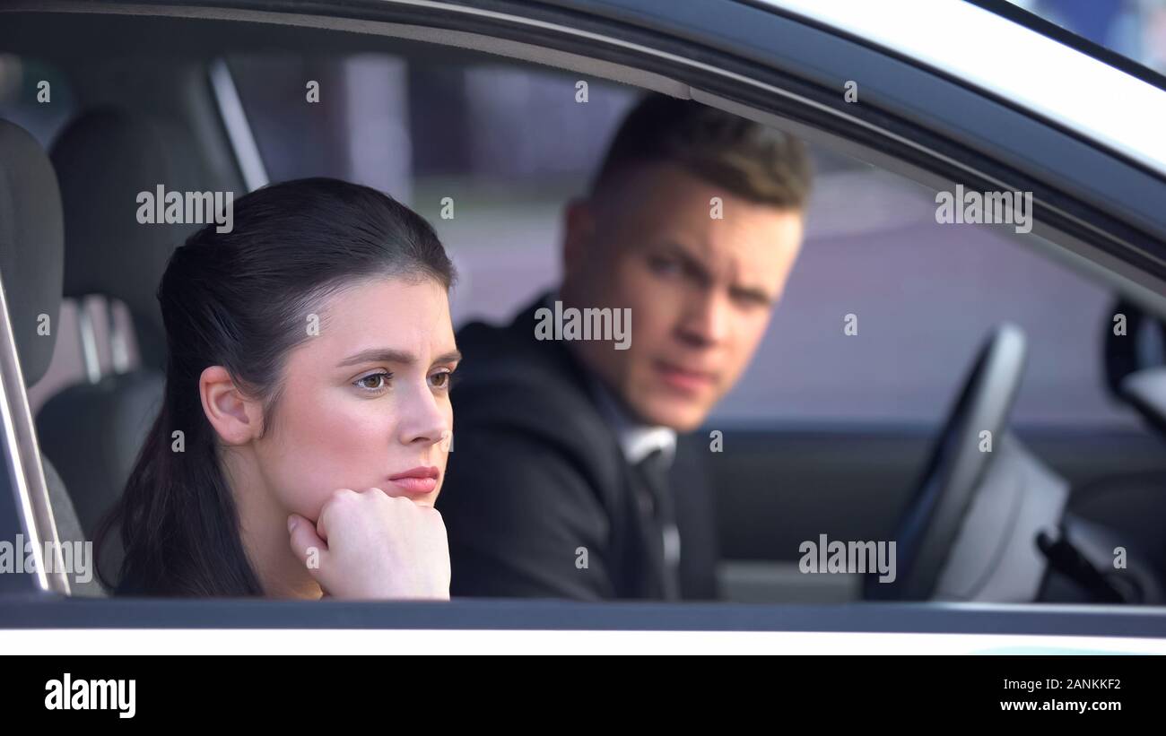 Agacé woman looking out of car window, mécontents après accord avec l'homme, le divorce Banque D'Images