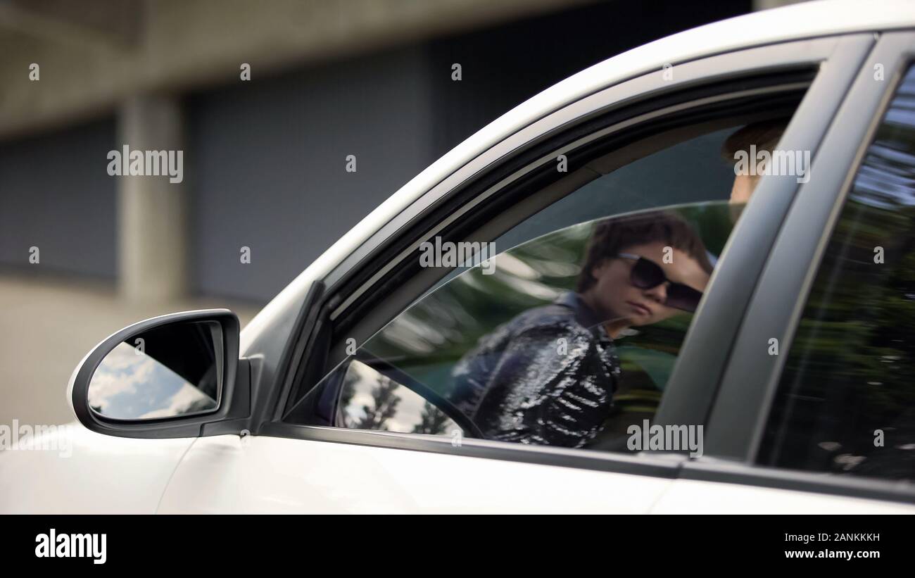 Célébrité féminine à la voiture à l'homme assis, invasion de la vie privée, les médias de masse Banque D'Images