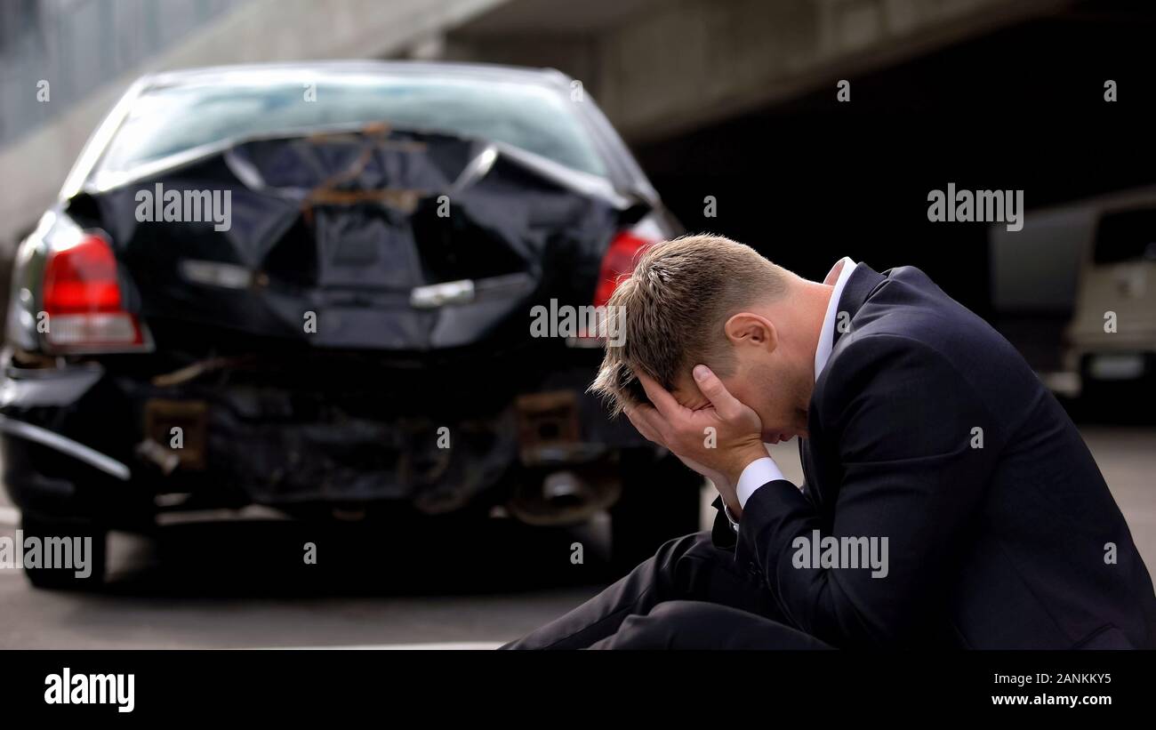 Pilote désespéré sur fond auto endommagé, brisé l'assurance pour le transport, la sécurité Banque D'Images