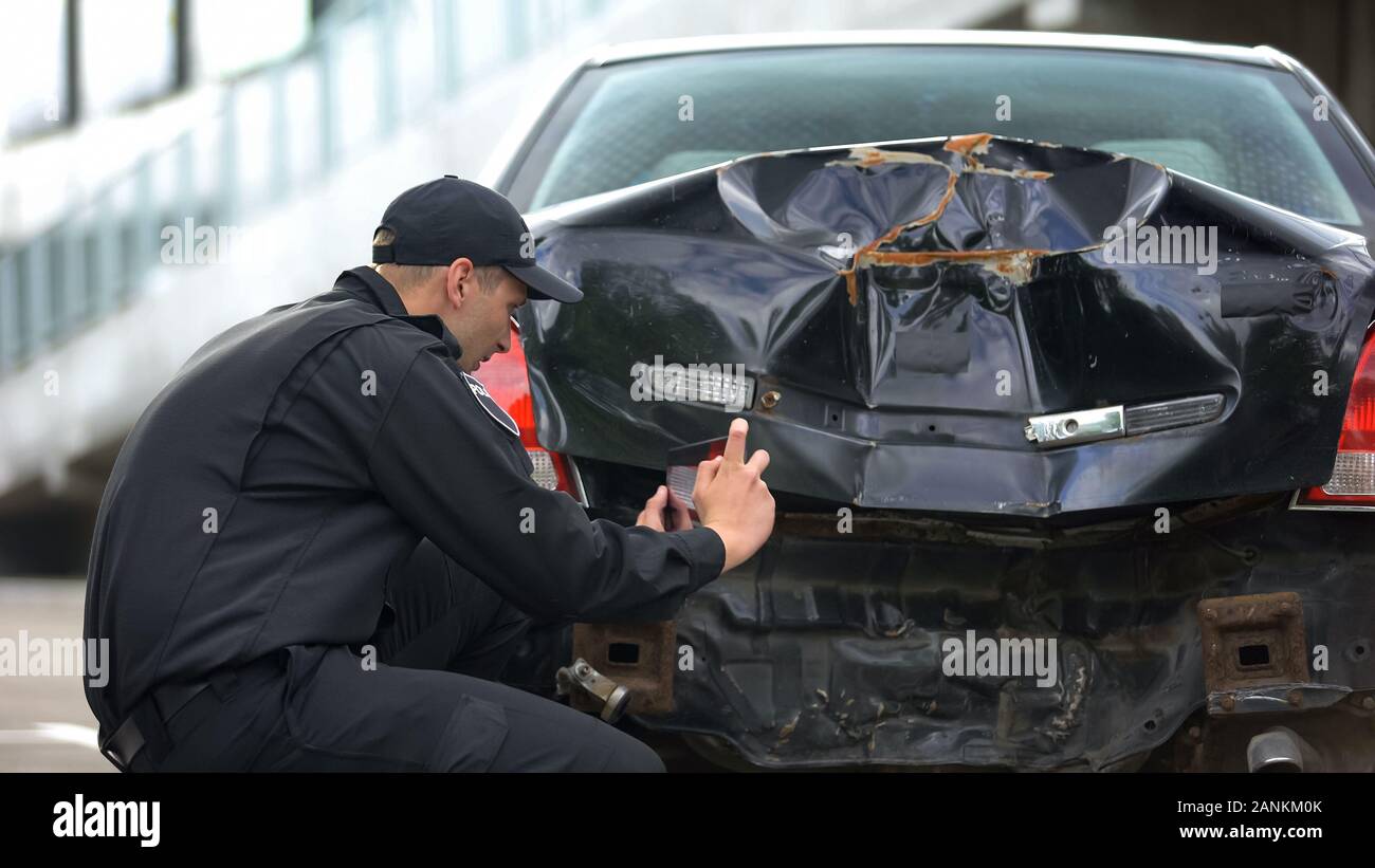 Agent de police de faire des photos de voiture s'est écrasé après accident de la route, rapport de remplissage Banque D'Images
