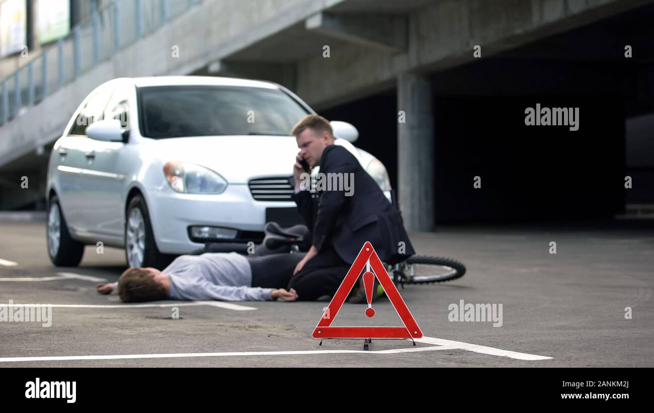 Triangle rouge sur route, homme d'urgence appelant après l'accident de voiture de location Banque D'Images