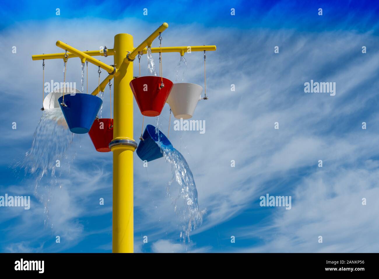 L'eau s'écoule hors de seaux en été, pour un splashpad park dans le soleil de l'été Banque D'Images