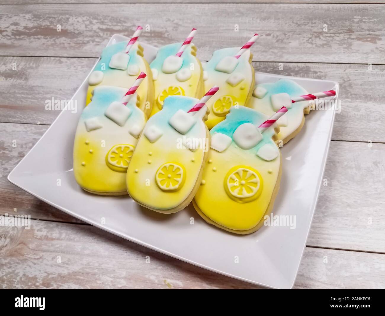 Libre de limonade d'été amusant pot Mason sugar cookies avec des pailles à rayures et des cubes de glace sur un plateau avec fond de bois Banque D'Images