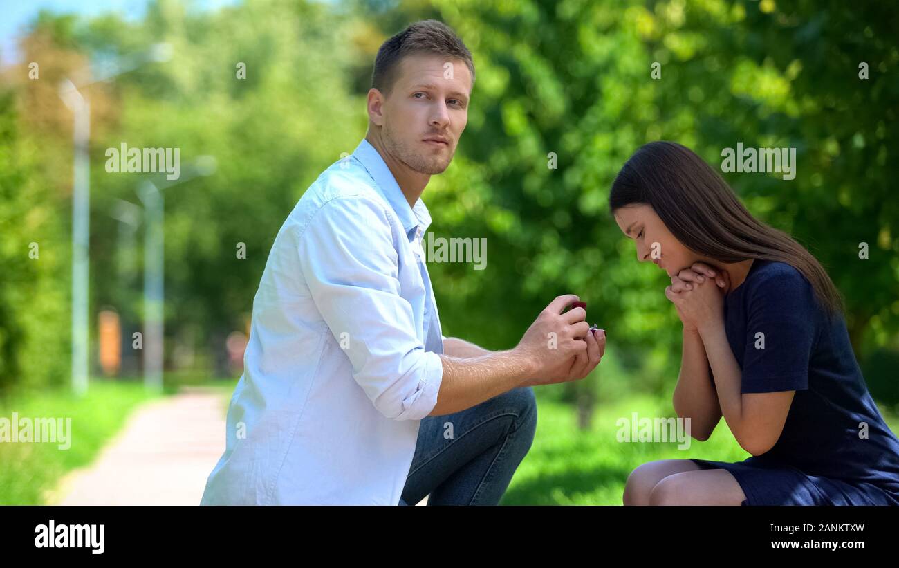 Naïve jeune femme admirant anneau de mariage dans la main d'ignorer les relations, petit ami Banque D'Images