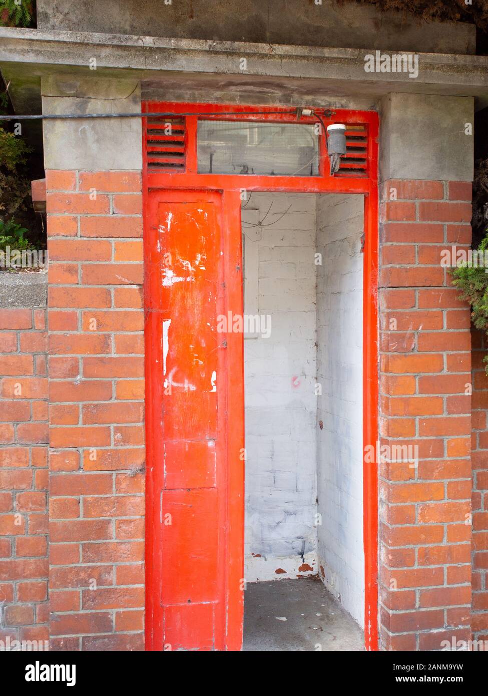Ancienne Cabine téléphonique rouge situé dans un mur de briques Banque D'Images