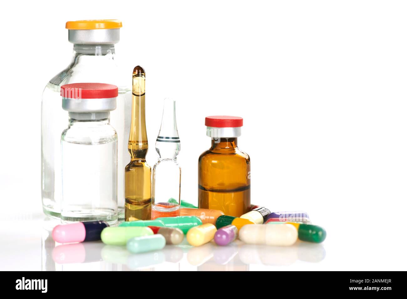 Divers médicaments flacons et ampoules avec plusieurs capsules colorées isolé sur blanc. Banque D'Images